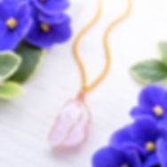 Raw rose quartz pendant hand-wrapped in brass wire on a 24-inch brass chain.