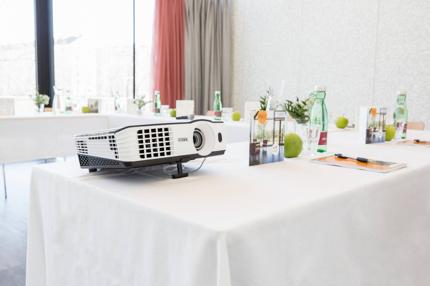 Aufnahme eines weiß eingedeckten Tisches auf dem ein Beamer steht.