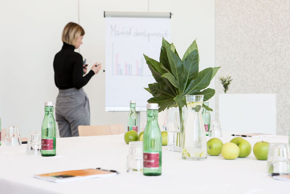 Vortragende bereitet sich vor, der Tisch im Vordergrund ist noch leer.