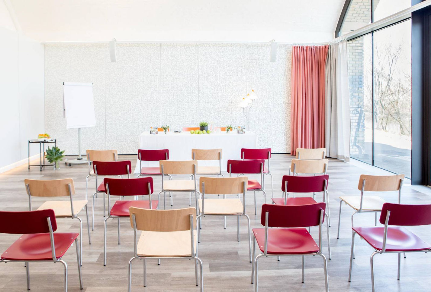 Sesselreihen mit Blick zu einem Pult am Ende des Raumes sind aufgestellt.