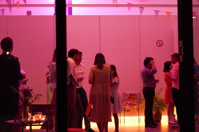 Lillis Stadtbahnbögen in rosa getaucht, Gäste stehen in Gruppen und plaudern.