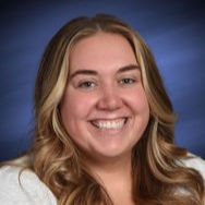 Smiling woman with long wavy hair, wearing a light top against a blue gradient background, conveying a cheerful mood.