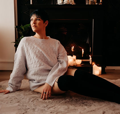 Ashley Stafford, kink companion, on a FMTY adventure, sitting on the floor surrounded by candles