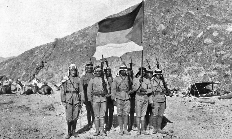 Des Arabes portent le drapeau du Royaume indépendant du Hedjaz pendant la révolte arabe en 1917.
