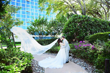Bride and groom wedding portrait in front of the Walt Disney Swan Reserve.