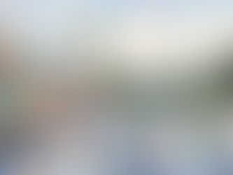 People ice skate on a rink in a vibrant town square with mountain views. Winter clothing, colorful buildings, and "ENTER" sign create a lively scene.