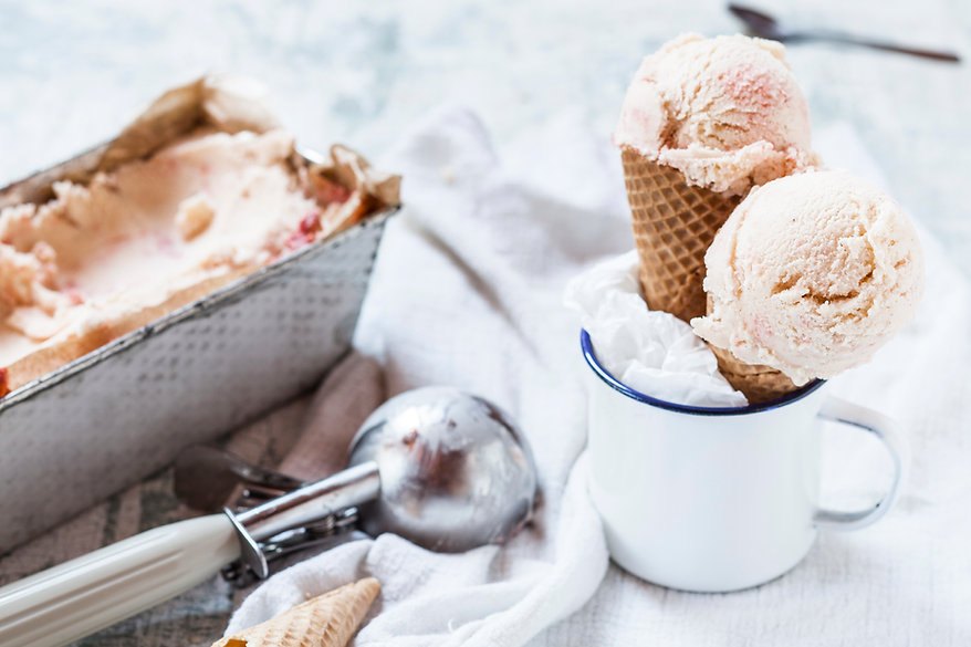 scooping homemade ice cream from tins into ice cream cones