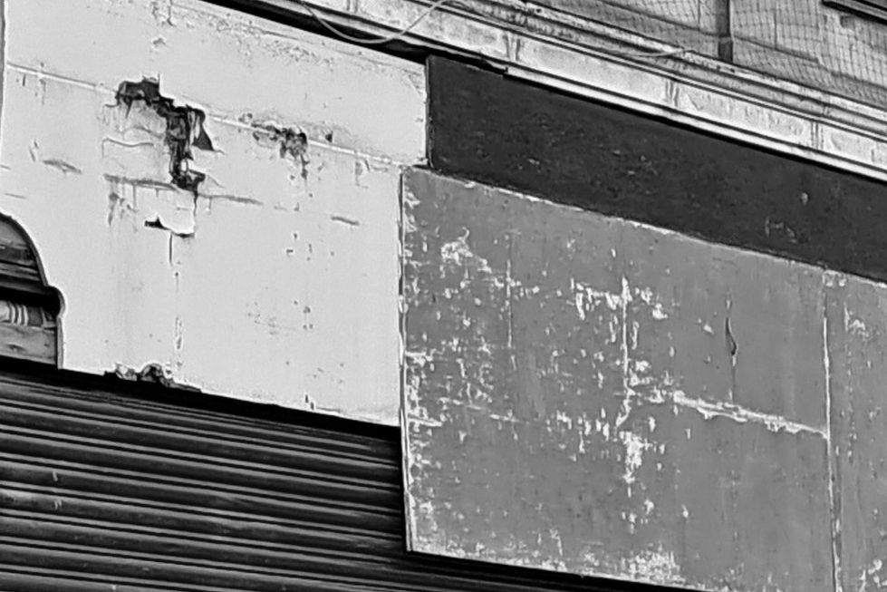 Woolies Facade
Photograph of the the boarded  up facade of what was once Woolworths' Store in Church Street. After the demise of Woolworths', the store was used by the Co-op to sell electrical goods. When the Co-op went into decline, eventually closing completely in Seaham, the store was Taken over by Ethel Austin, selling budget clothing. Then it became a second-hand furniture and clothes shop bearing the name of 'Charity's' but beware, this was no charity shop but a private enterprise. Finally, at the time when the photograph was taken, it the store became an axe-throwing venue. 
At the time of writing, summer 2025, the store is being refurbished, the broken hoarding has been removed and a new frontage is emerging. This is being achieved under the auspices of the Townscape Project. Perhaps it signifies something of the regeneration process underway in Seaham. 