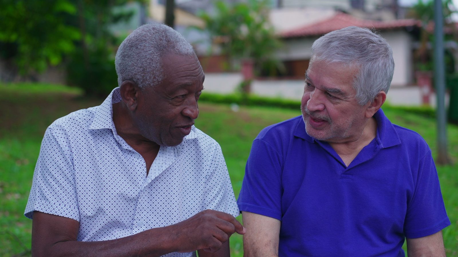 Two older men talking and laughing on a park bench