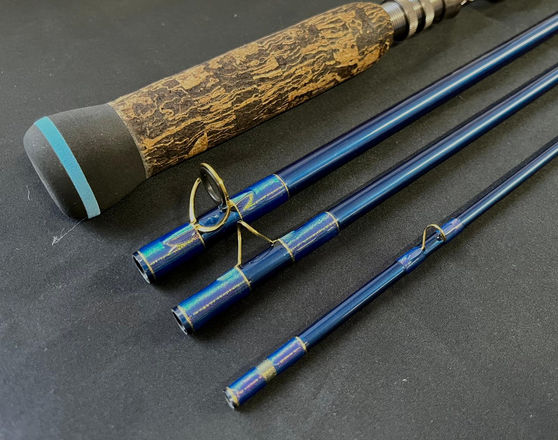 custom build made fly fishing rod with a dark mottled cork grip with custom rings and special blue paint work and whipping
