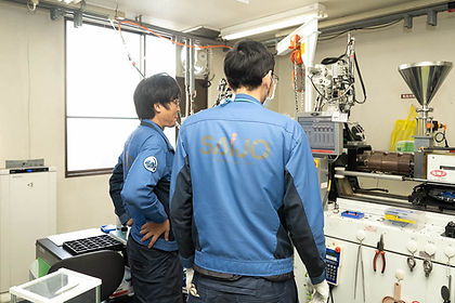機械の前で打ち合わせする二人の社員