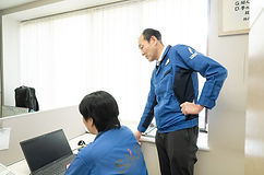 PCを見て打ち合わせする社員2名