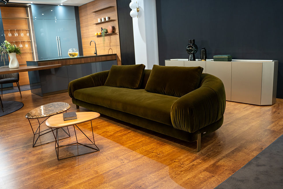 Divano verde oliva, tavolini e credenza in esposizione. Arredamenti De Martino.