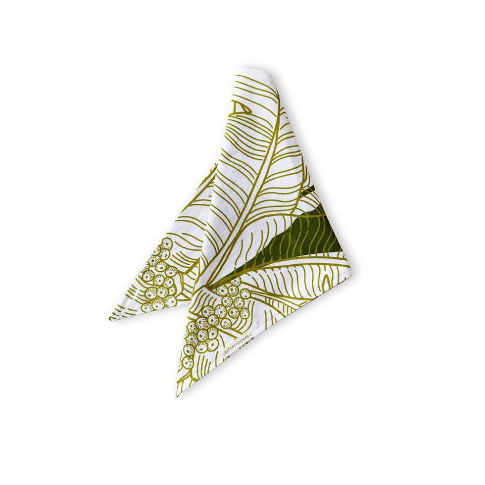 A white bandana with a banana leaf pattern in green with gold outline art. Spoonflower fabric designed by HNLdesigns.