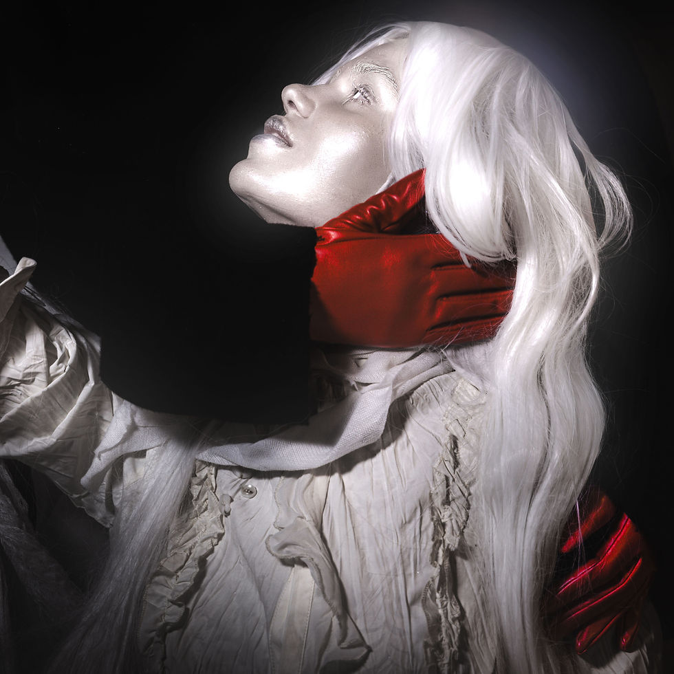 Pale mannequin-like figure with long white hair, red gloves at neck, and white ruffled dress against black background.