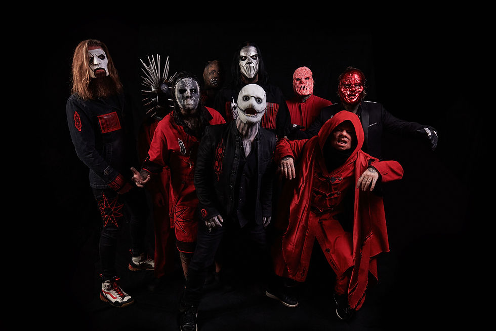 Masked heavy metal band in black and red outfits posing against a dark studio background, with eerie skull and horror masks.