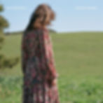 A woman in a floral dress stands in a grassy field, looking down. Text says "Jenny Gillespie Mason" and "In the Safety of the Light."
