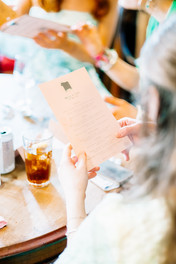 Close up of hands holding a pink menu
