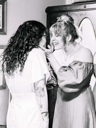 Bridesmaid holding Bride's face and smiling