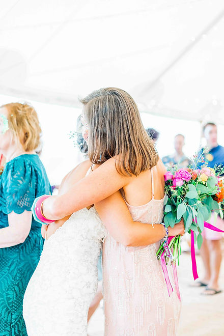 Bride hugging her friend who is wearing a pink sequin dress