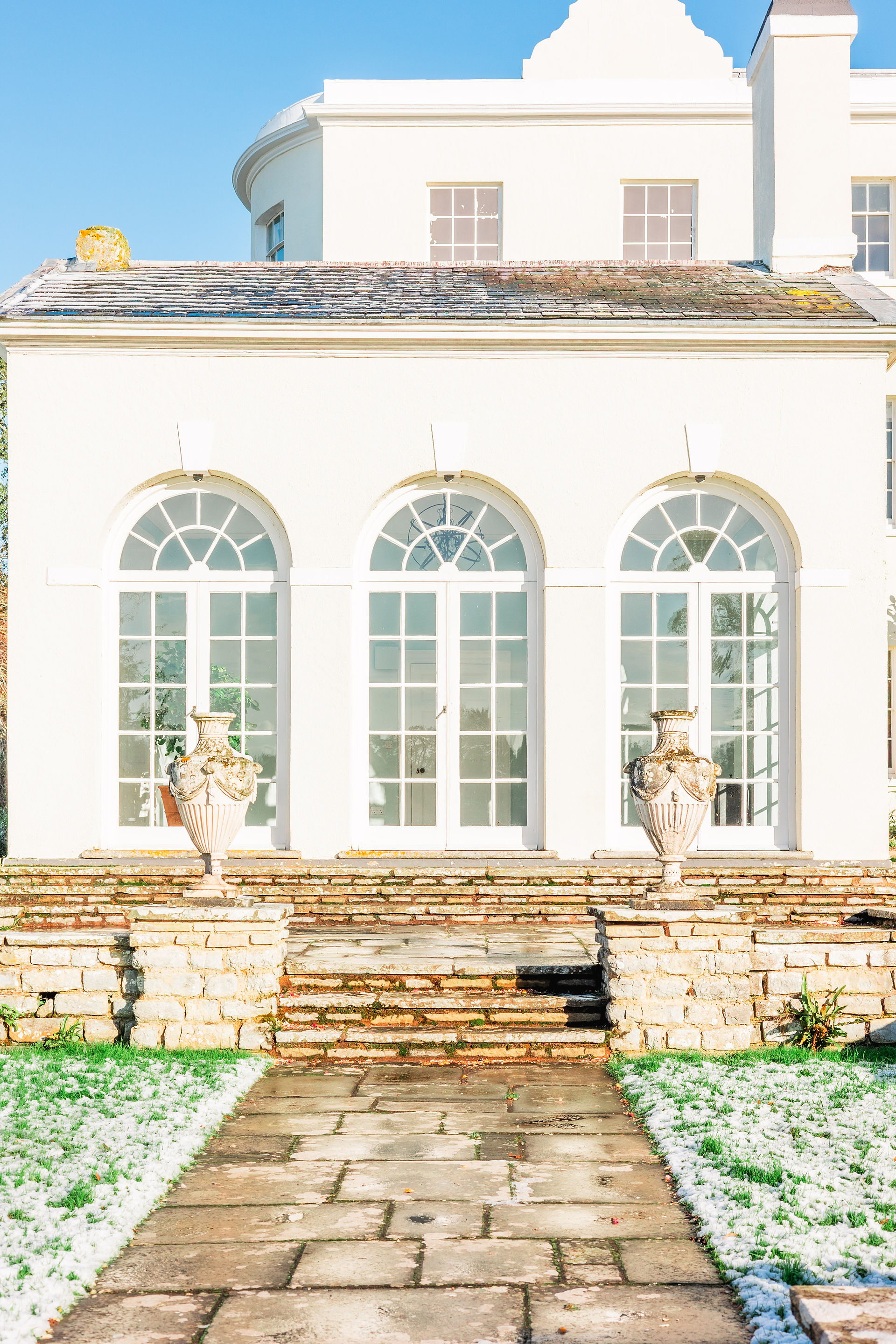3 arch windows on the pavilion of a white regal building in Devon. Rockbeare Manor, Exeter