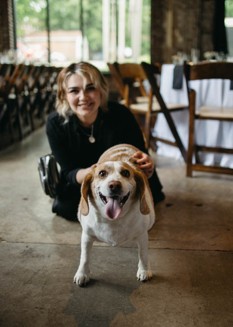 Elegant Paws sitting with a dog during a wedding
