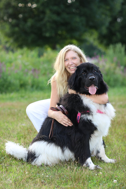 Rising Sun founder Rebecca White hugging a Newfoundland dog outdoors