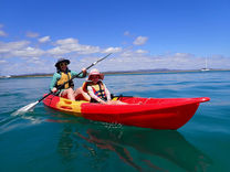Mother and young daughter on a red double kayak