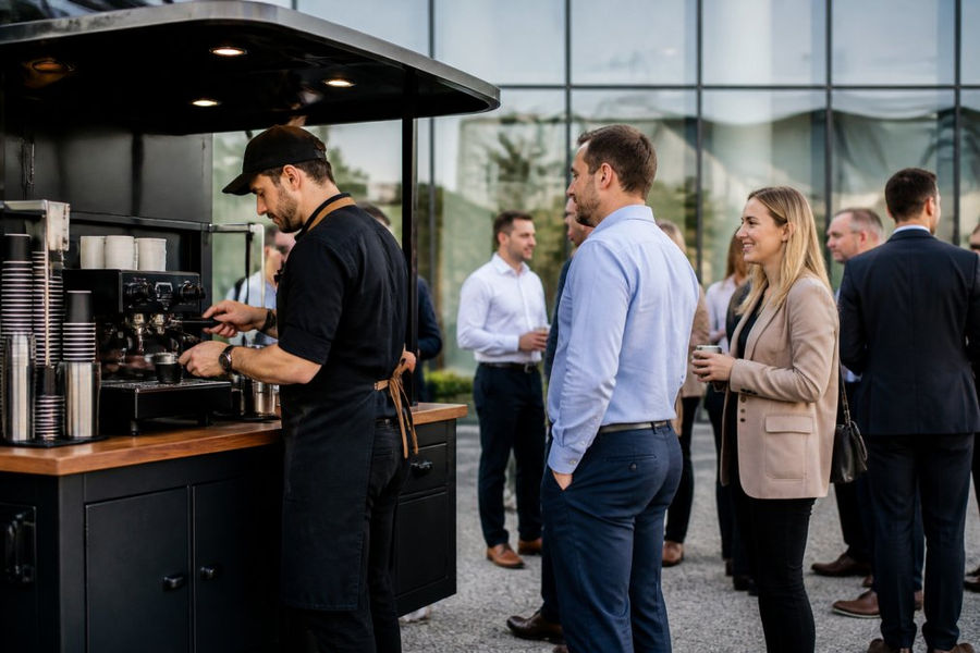 Barista pulling espresso shots at a mobile coffee catering cart for corporate event guests