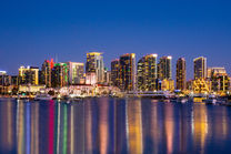 Downtown San Diego skyline with lights reflecting in water during twilight 