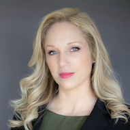 Blonde woman black business jacket olive blouse posing for professional headshot