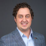 A smiling man in a suit and tie, representing a corporate team in San Diego headshots.