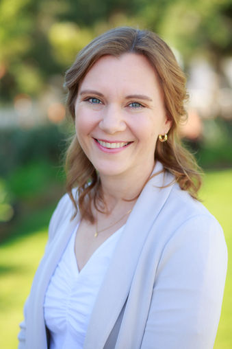 Redhead-woman-grey-tan-cardigan-white-blouse-posing-for-headshot-photo-Omni-La-Costa-photographer