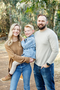 Family of three posing during family session at Batiquitos Lagoon