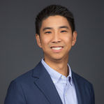 Smiling man in a blue suit and white shirt, featured in team headshots for a San Diego-based company.