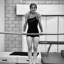 A gymnast holds a front support shape on a bar