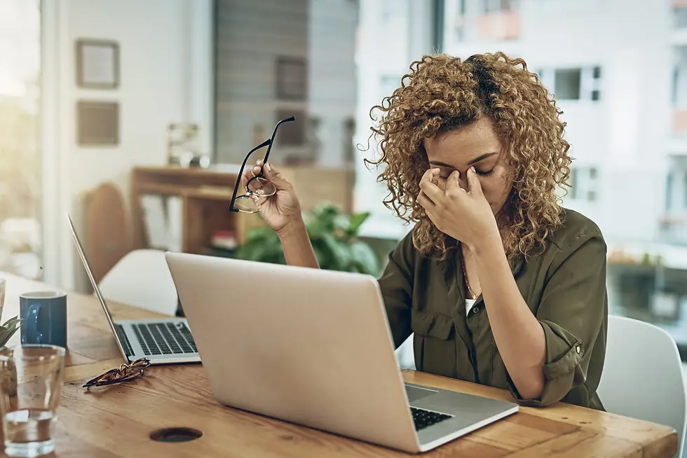 Stressed entrepreneur sitting at a desk, holding her head in frustration, symbolizing the overwhelming pressure of business growth that can lead to burnout, poor decisions, and strained relationships. Randy Belham, Montreal's best life coach for entrepreneurs, emphasizes the importance of inner peace as a key to sustaining long-term performance and well-being.