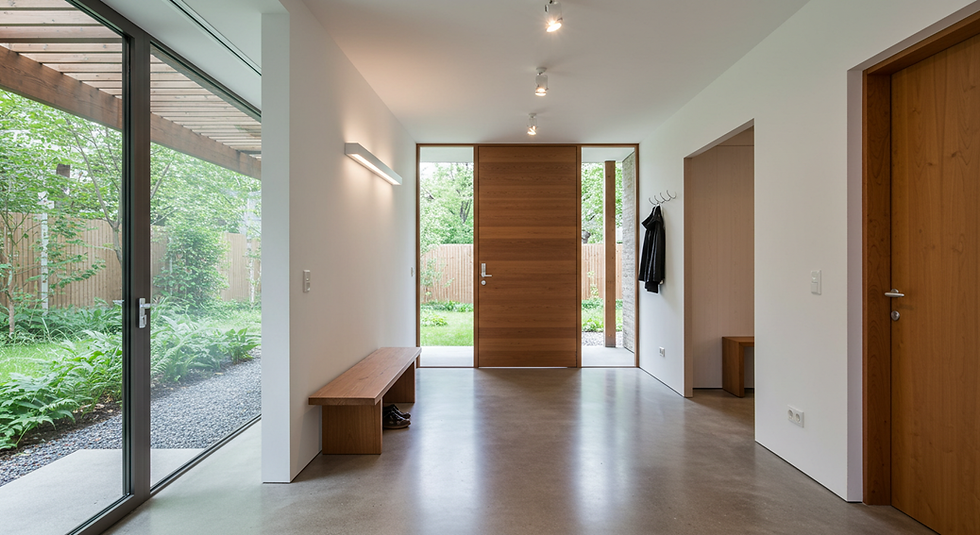 2025 trentlerine göre tasarlanmış modern, endüstriyel, ferah bir evin girişi, zemin mikrobeton, duvarlar beyaz renge boyanmış.