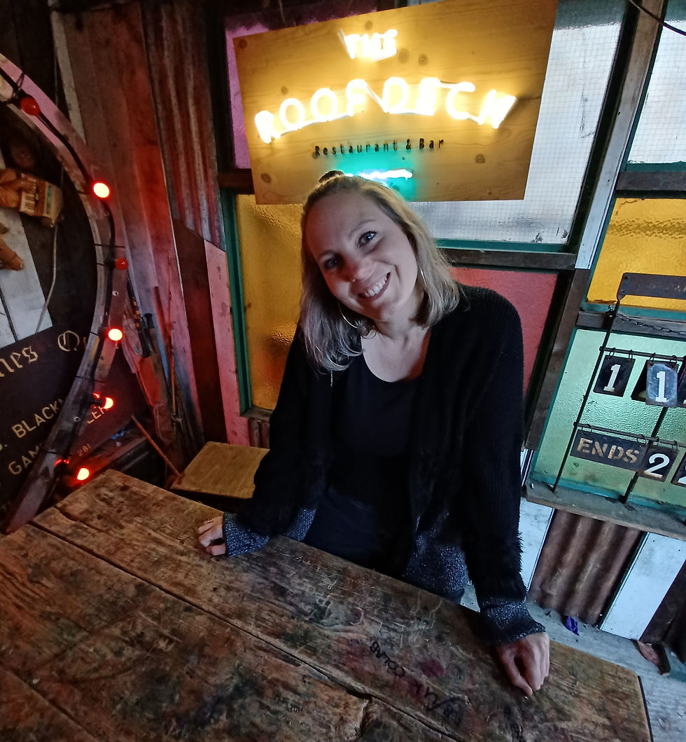 Me smiling to the camera with neon signs all around me