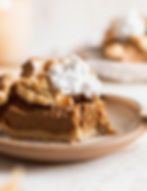 a slice of pumpkin pie close up with whipped cream on top