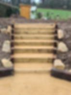 Wooden Garden steps with large stones on either side