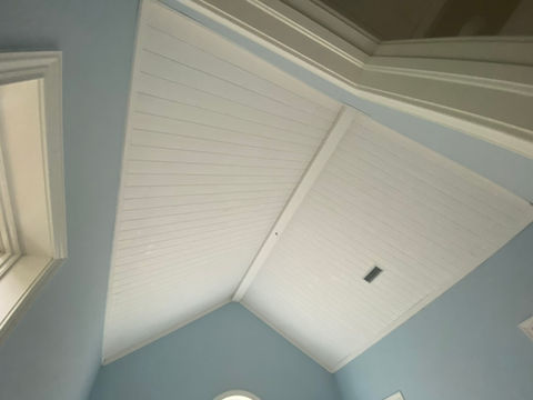 White tongue-and-groove vaulted ceiling with exposed center beam installed in a Ponte Vedra Beach home by AVP Construction JAX.