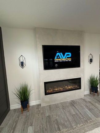 Modern living room with a textured fireplace wall, built-in electric fireplace, mounted TV, and natural decor in Nocatee, Ponte Vedra Beach, and Riverside homes.