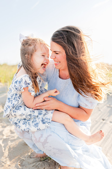 Mom and daughter laughing on the beach