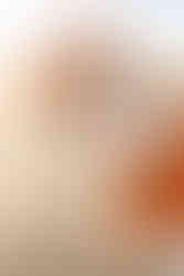 Family of three tickling daughter during golden hour at the beach