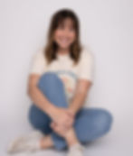 Bre, owner and pet photographer for The Photo District, poses for her headshot in front of a white backdrop.