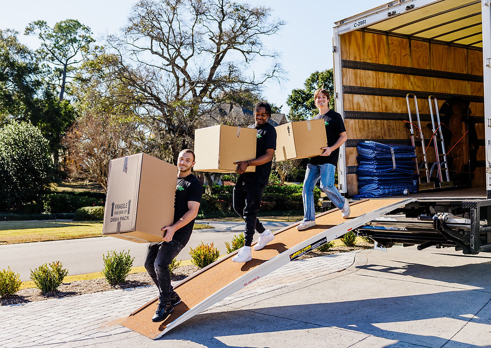 Big Green Box Moving crew carrying boxes down a truck ramp at a Wilmington, NC home