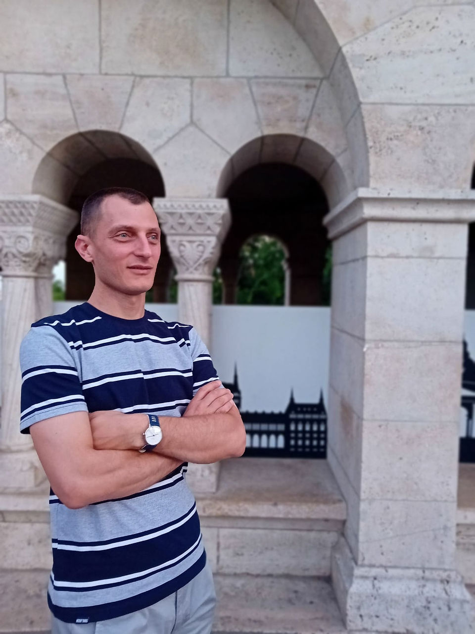 Férfi áll a budapesti épület előtt, karba tett kézzel. 08.12. | A Love Story vitt mindent Budapesten