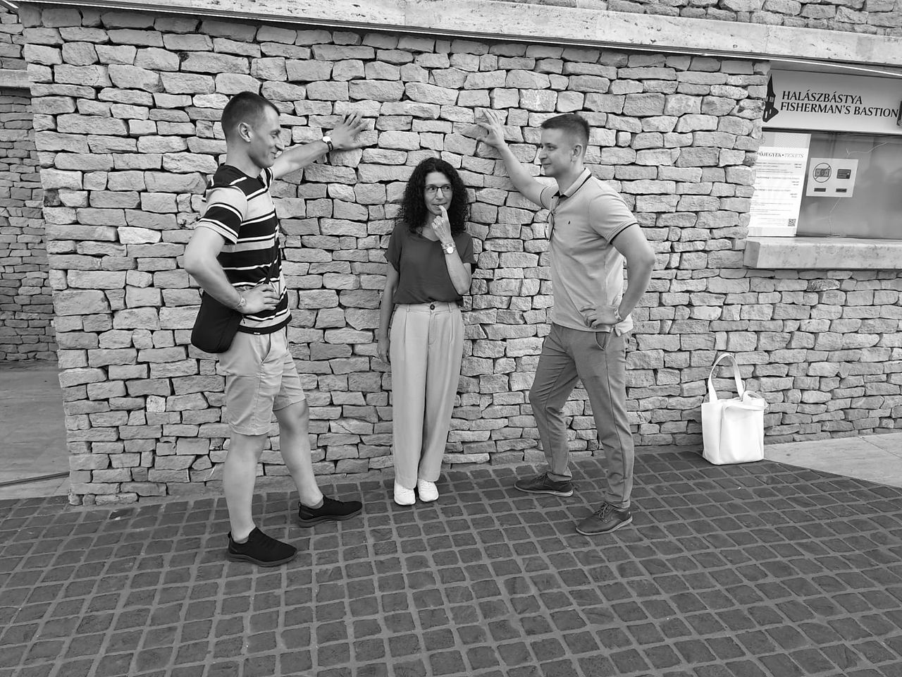 Három ember pózol egy fal előtt, egyikük gondolkodik. 08.12. | A Love Story vitt mindent Budapesten