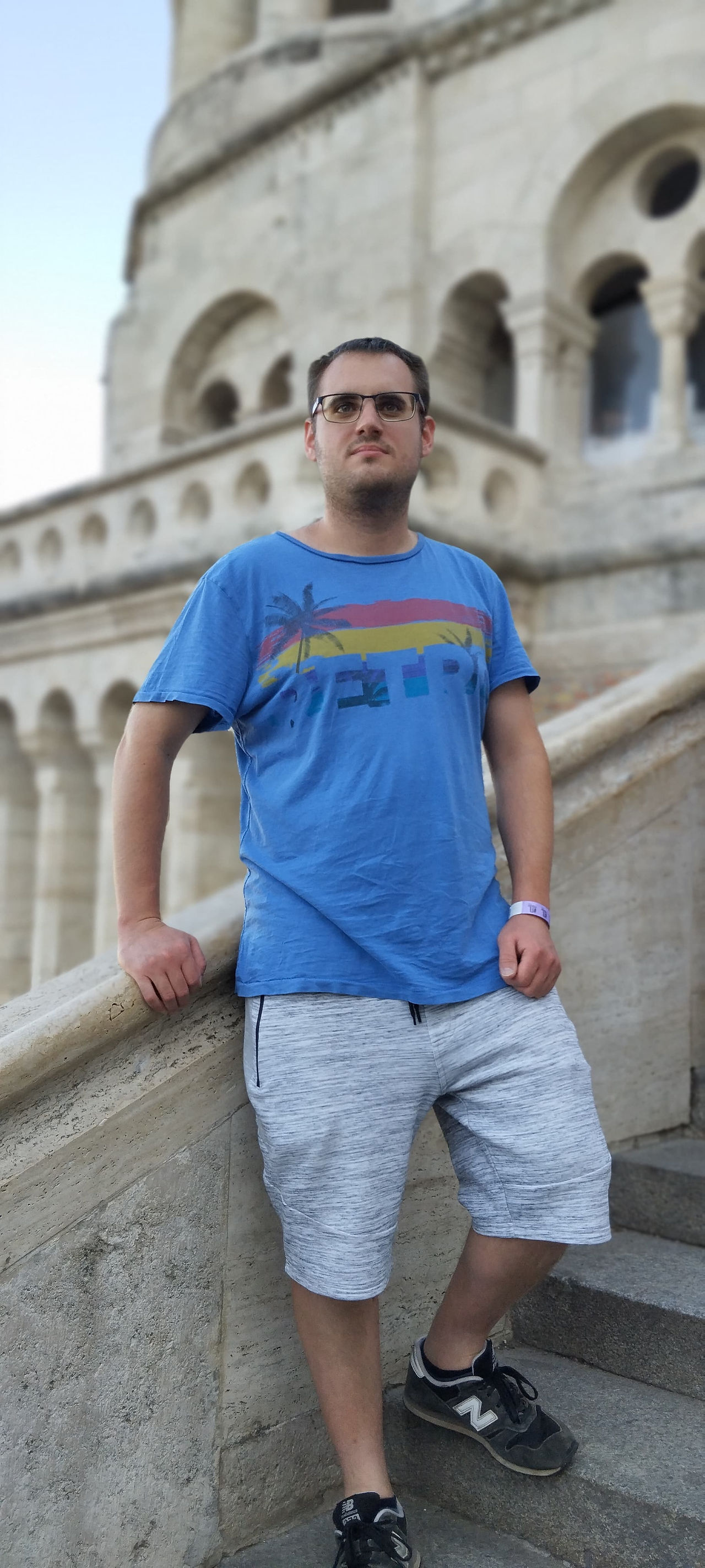 Férfi áll a lépcsőn, kék pólóban, Budapesten. 08.12. | A Love Story vitt mindent Budapesten.